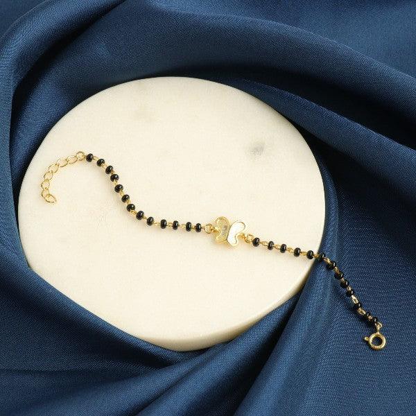 Elegant 925 silver butterfly kids bracelet KB-140 with adjustable chain displayed on a blue satin fabric.