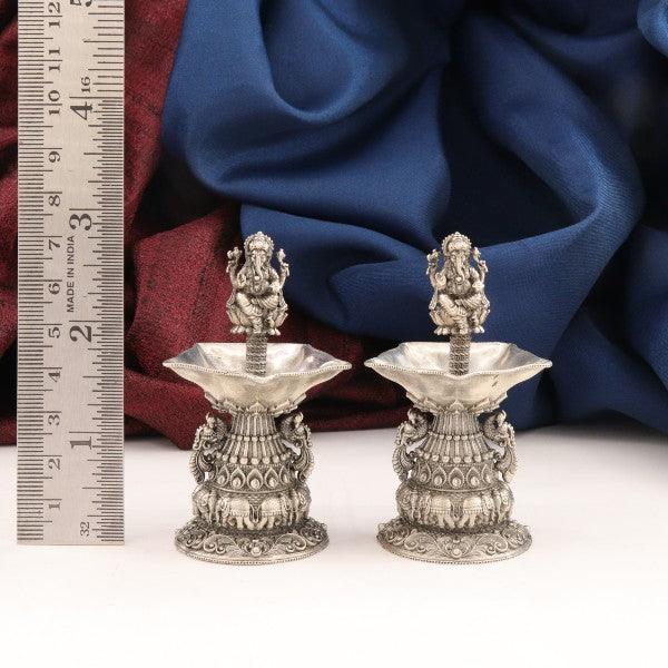 Intricate 925 silver 2D Ganesha Deepam AD-35, pair of 109g lamps with detailed designs, shown with a ruler for scale.