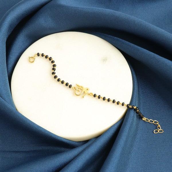 925 Silver Shalin Kids Bracelet KB-152 on blue fabric background, featuring delicate black beads and a gold charm.