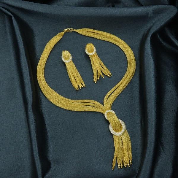 Golden necklace and earring set displayed on a dark green fabric background