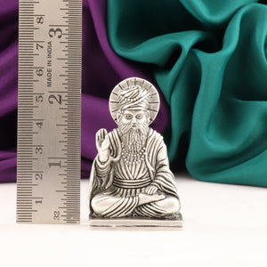 925 Silver 2D Guru Nanak Idol, 59g, 6cm Length, Made in India, against colorful fabric and a ruler.