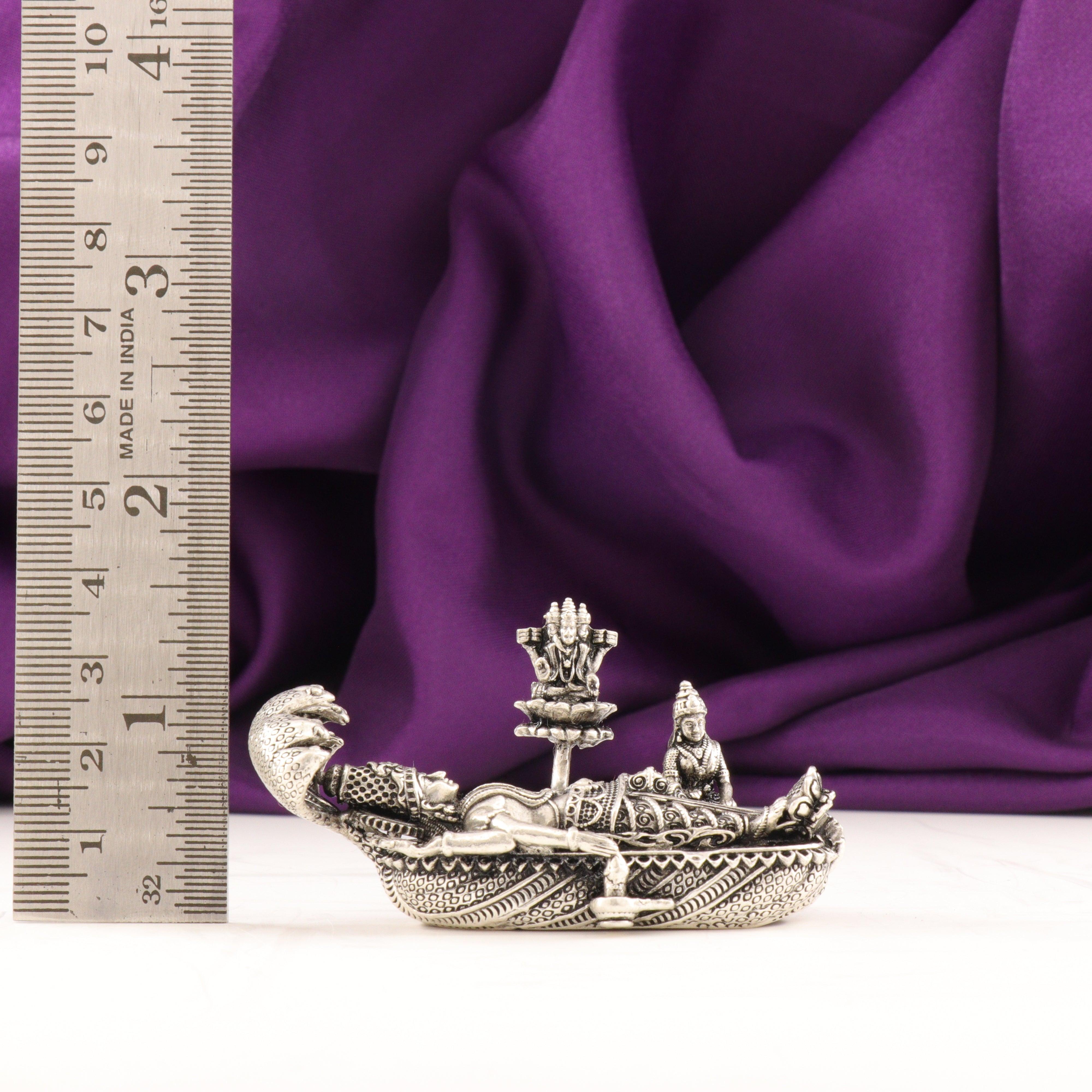 925 silver 3D Anandha Padmanabha Swamy idol, 6cm, 67g, against a purple fabric background, showcasing intricate details with a measuring ruler for scale.