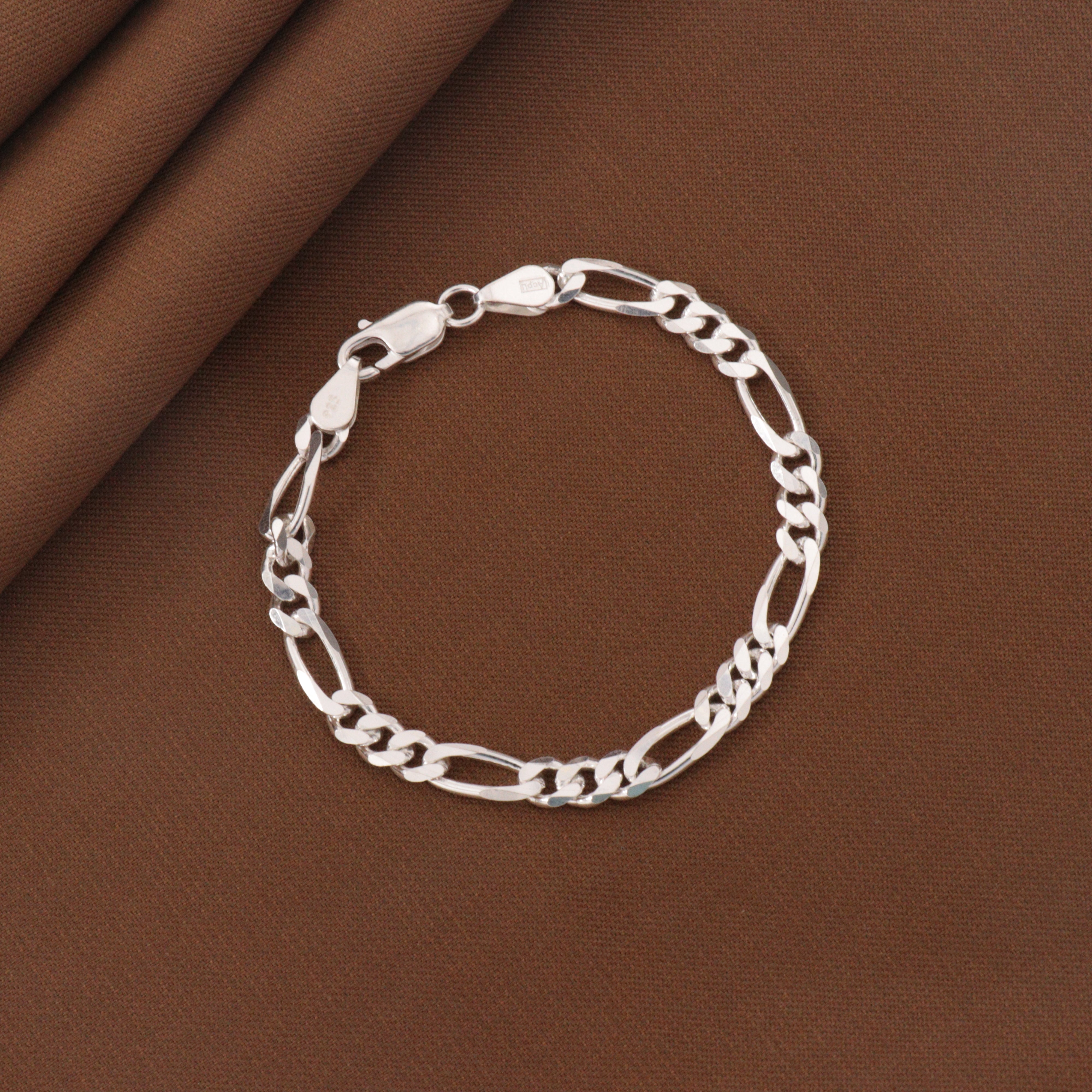 925 silver Manmohan kids bracelet KB-196 weighing 9g and 18cm long, displayed on a brown fabric background.