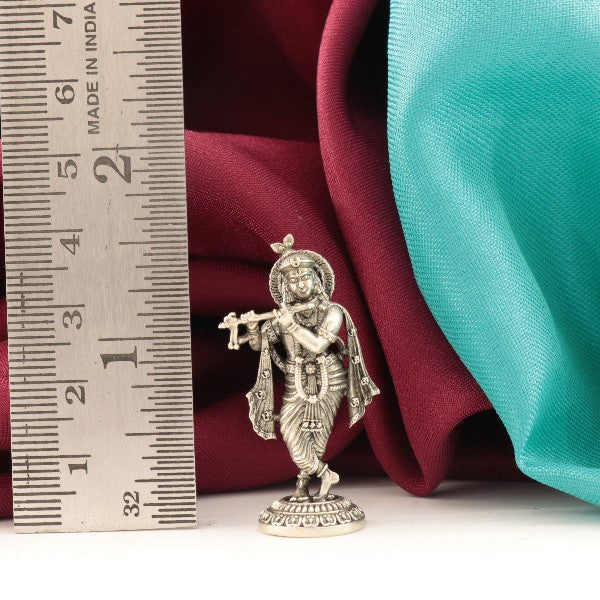 925 silver 3D Krishna idol measuring 4cm in height and weighing 12g placed beside a ruler for scale.