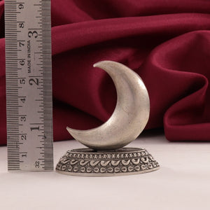 925 silver 2D moon idol with intricate base, 6 cm in height, weighing 40g, placed next to a ruler with a red fabric backdrop.