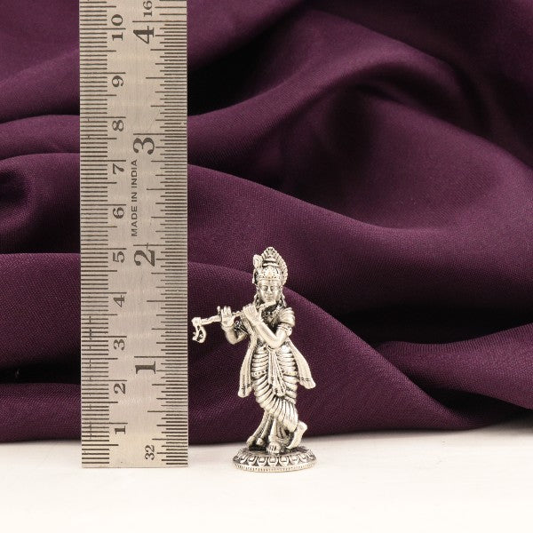 925 silver 3D Krishna idol weighing 26g and measuring 5cms, showcasing fine craftsmanship against a purple fabric background with a measuring scale.