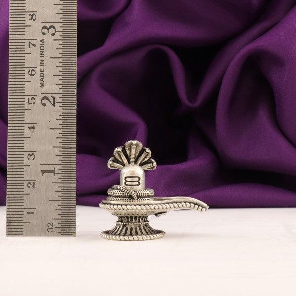 3D Shivling idol made of 925 silver weighing 47g and measuring 3.5cms in front of a purple fabric backdrop with a ruler.