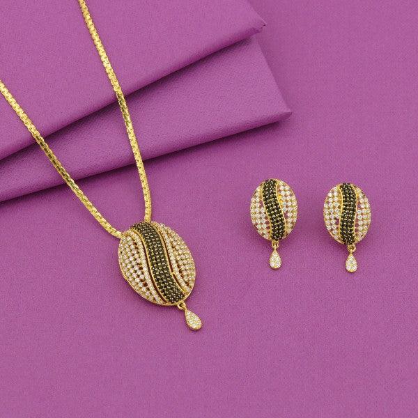 Elegant gold necklace with matching earrings featuring oval-shaped pendants adorned with green and white stones, presented on a purple background.