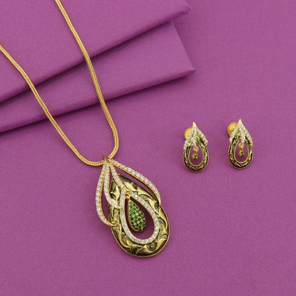 Elegant gold necklace and earring set with green gemstone on purple background.