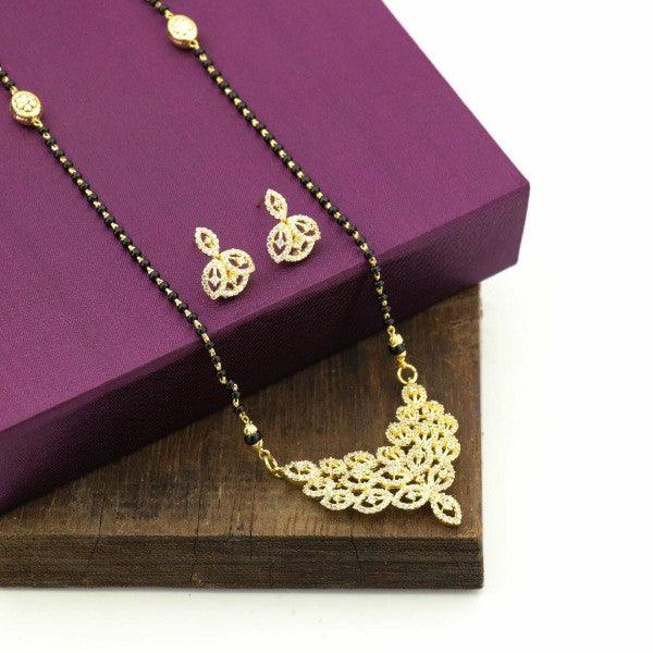 Golden necklace and earrings set displayed on a purple jewelry box