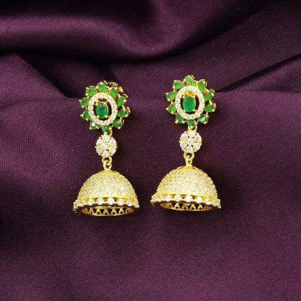 Gold and green beaded jhumka earrings against a purple fabric background