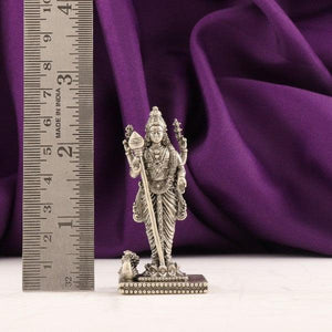 925 silver 3D Murugan idol weighing 54g with a height of 6.5cms placed next to a ruler for scale, purple background.