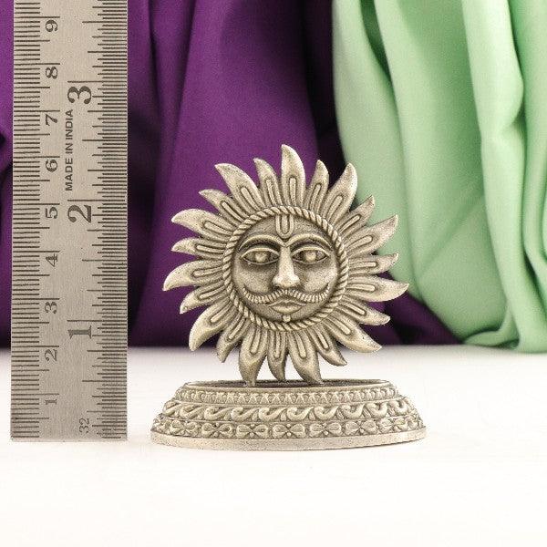 925 silver 2D sun idol weighing 47 grams with a dimension of 6.5 cms displayed next to a ruler and cloths.