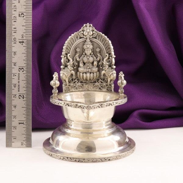 925 silver Gajalakshmi deepam with intricate design, weighing 174g and 2D structure, displayed against a purple fabric with a measuring ruler.