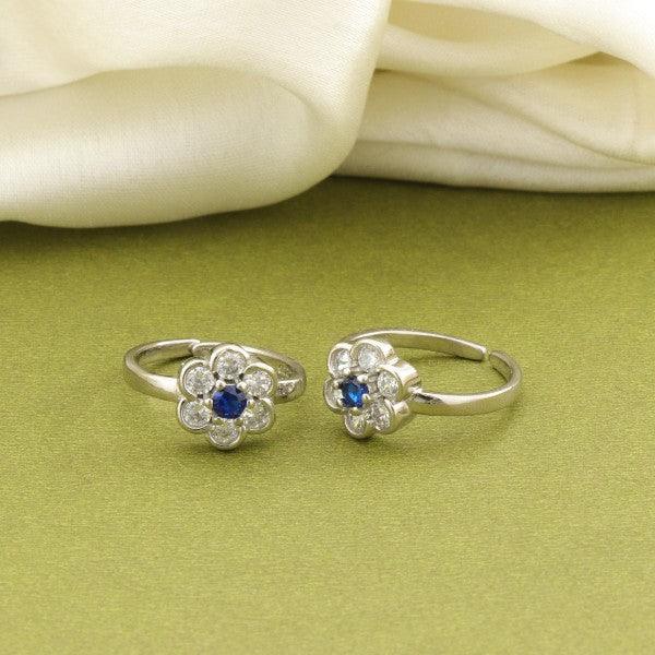 925 silver Meera women toe-rings with blue gemstones and flower design on green surface.