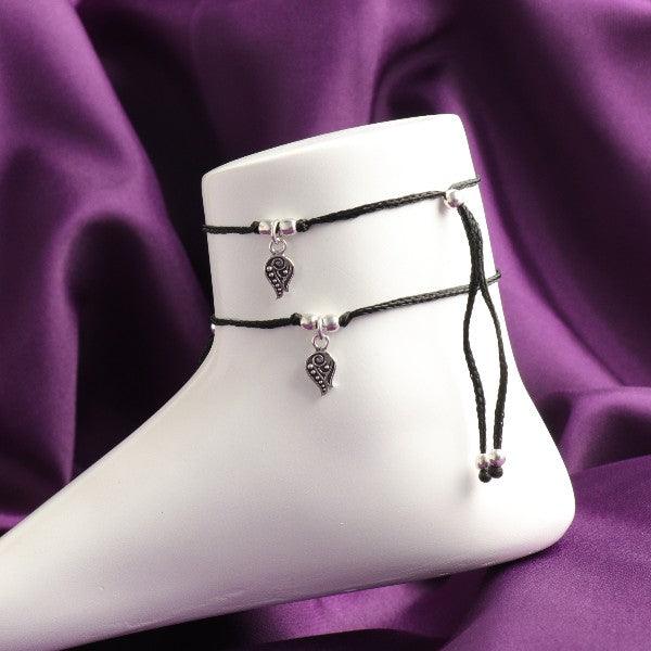 925 silver Ulupi women anklets ANK-135 with adjustable black cords and dangling silver charms on a white mannequin foot