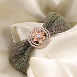 Elegant hair accessory with a flower design and sparkling accents on a folded fabric background