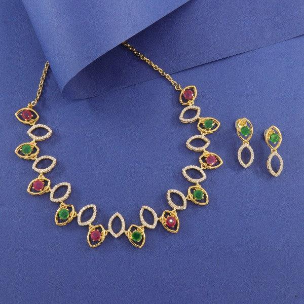 Elegant gold necklace with red, green stones and matching earrings on blue background.